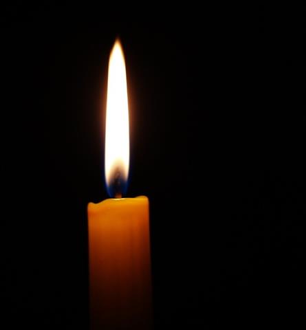 eine brennende Kerze im Dunkeln